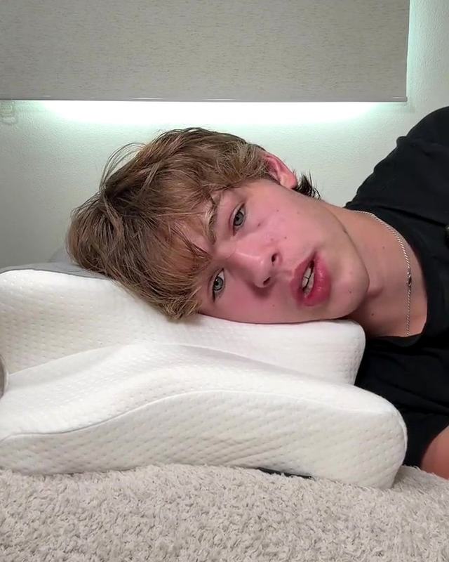 Persona durmiendo de lado con la almohada cervical